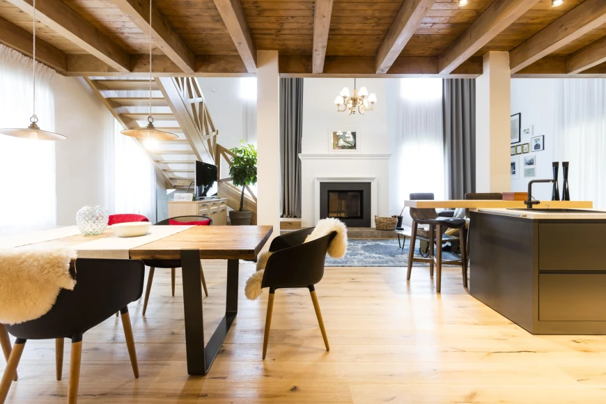 R1Centrum Bratislava centrum bývania - Horák Interiéry kuchyňa a jedálenská časť, drevený stôl, kuchynský ostrovček, krb, drevený strop a nábytok na mieru