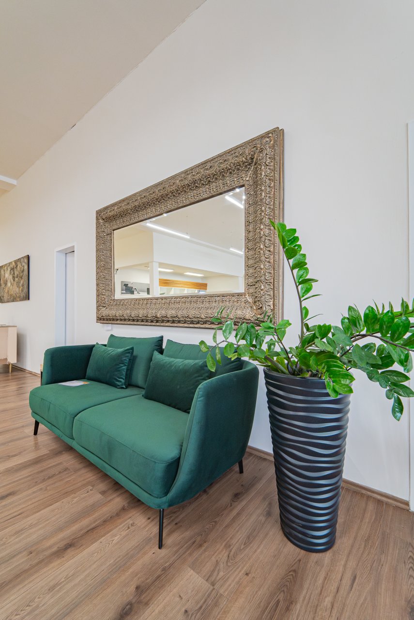 R1Centrum Bratislava centrum bývania - Sofa Partners zelené kreslá, sedačky, veľké zrkadlo, izbové rastliny a moderný obývací interiér