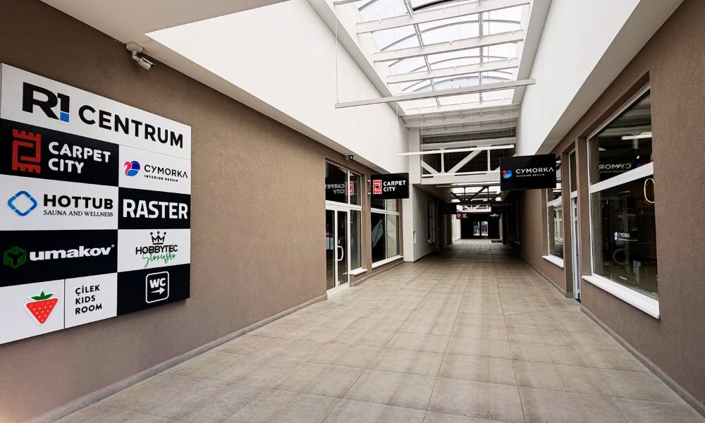 Krytá pasáž s predajňami Carpet City a Cymorka a tabuľa s obchodmi v R1 Centrum Bratislava